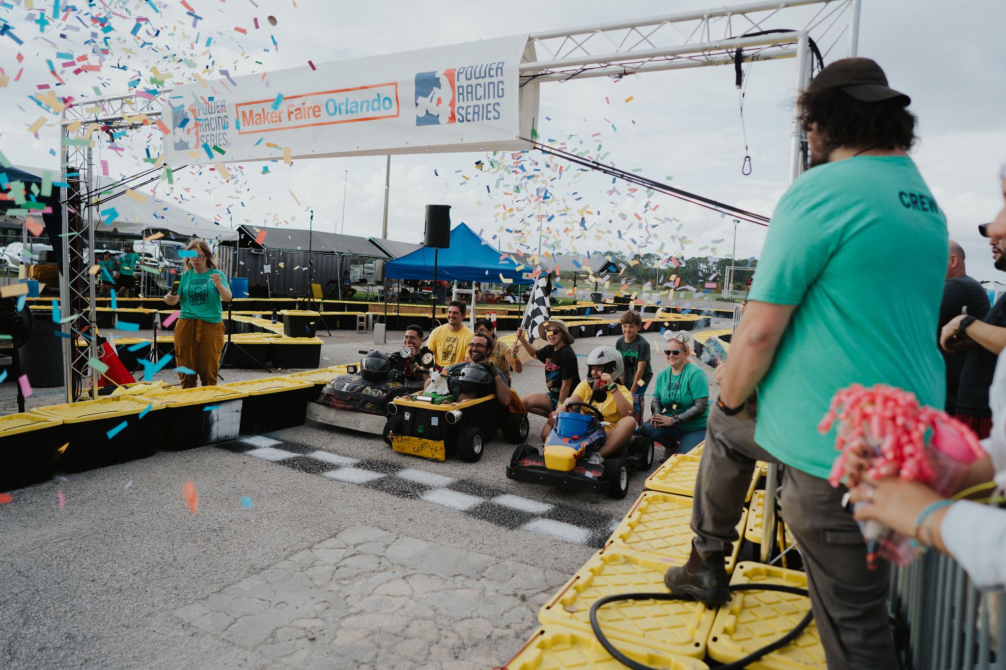 Crew and racers celebrating under the confetti at the Power Racing Series finish line